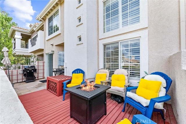 deck featuring an outdoor fire pit and area for grilling