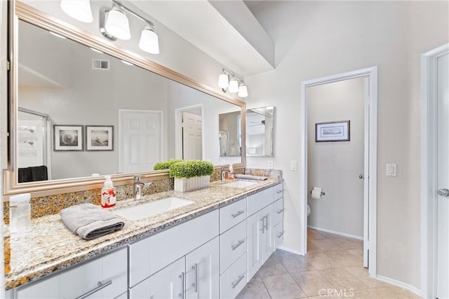 full bathroom featuring double vanity, visible vents, a sink, and tile patterned floors