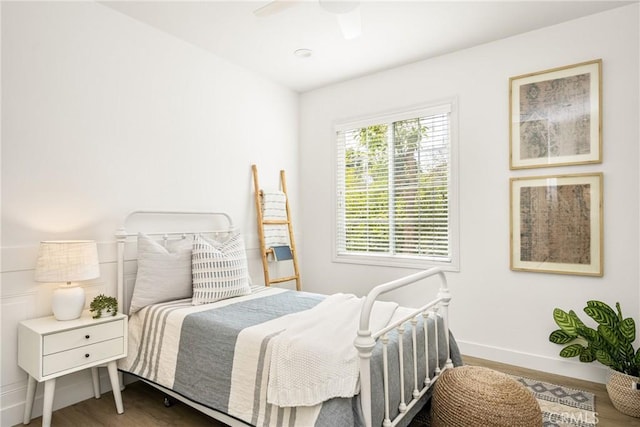 bedroom with a ceiling fan, baseboards, and wood finished floors