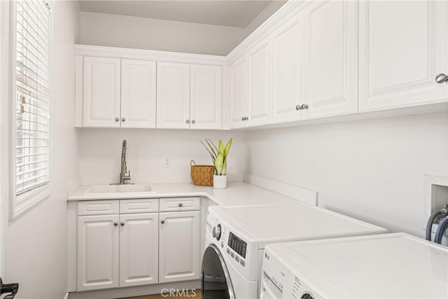 washroom with cabinet space, separate washer and dryer, and a sink