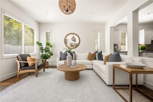 living room featuring baseboards, recessed lighting, and light wood-style floors