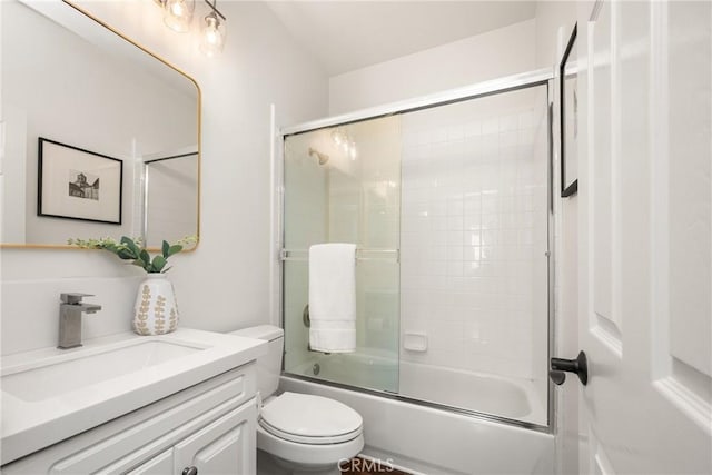 full bath with enclosed tub / shower combo, vanity, and toilet