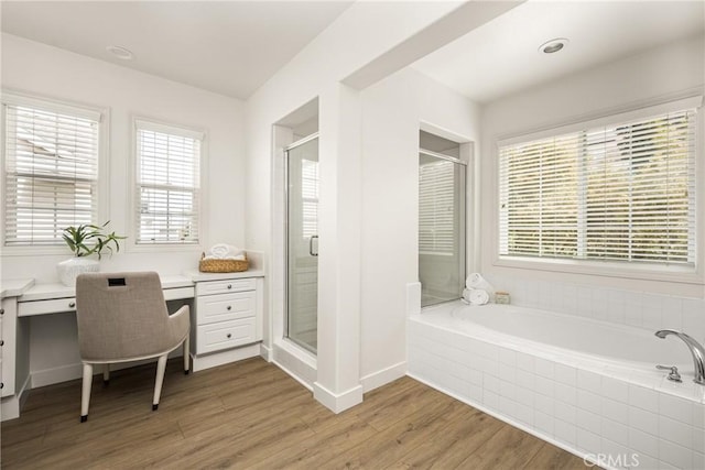 bathroom featuring a stall shower, plenty of natural light, vanity, and wood finished floors