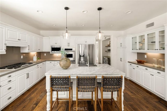 kitchen featuring stainless steel appliances, dark wood-type flooring, visible vents, and white cabinets