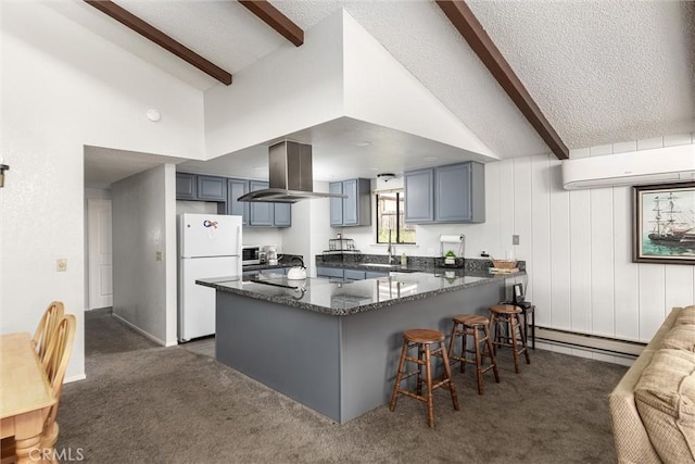 kitchen featuring island range hood, a wall mounted air conditioner, a peninsula, freestanding refrigerator, and beam ceiling