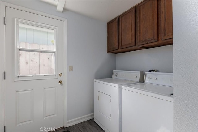 clothes washing area with baseboards, cabinet space, washing machine and clothes dryer, and wood finished floors