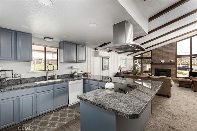 kitchen with white dishwasher, island exhaust hood, black electric stovetop, a brick fireplace, and a sink