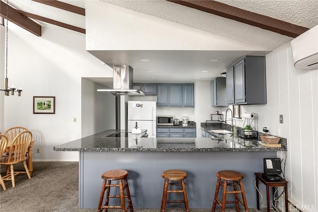 kitchen featuring gray cabinets, stainless steel microwave, freestanding refrigerator, a sink, and island range hood