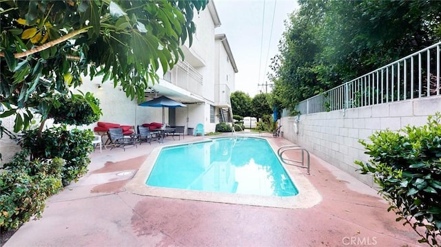 view of swimming pool with a fenced in pool, fence, and a patio