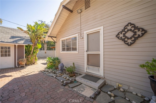 entrance to property featuring a patio and fence