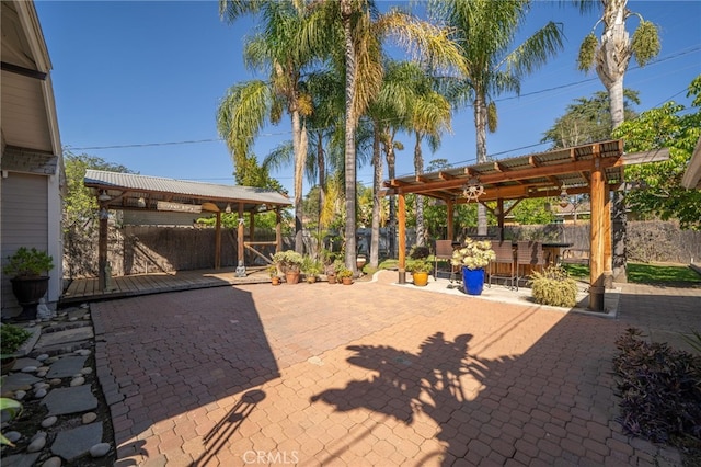 view of patio / terrace featuring a fenced backyard, a pergola, and outdoor dry bar