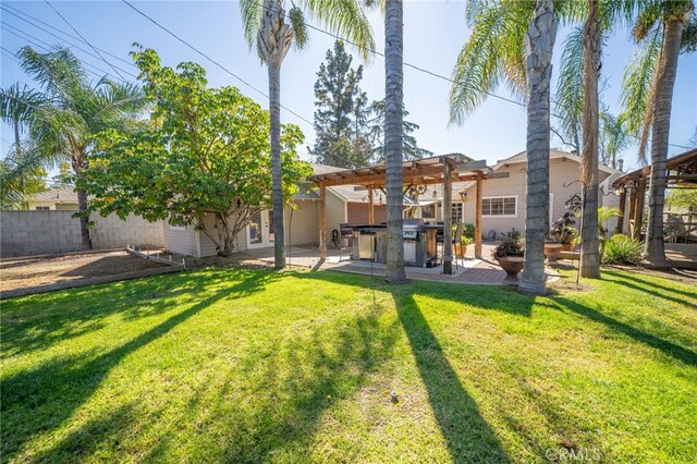 rear view of house with a patio area, a pergola, a yard, and fence