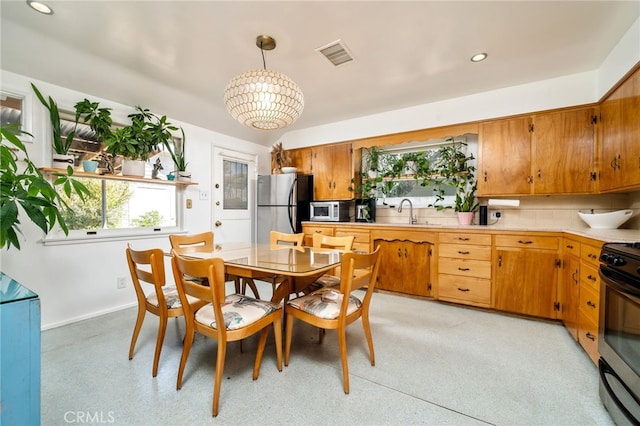 kitchen featuring tasteful backsplash, appliances with stainless steel finishes, light countertops, and a wealth of natural light