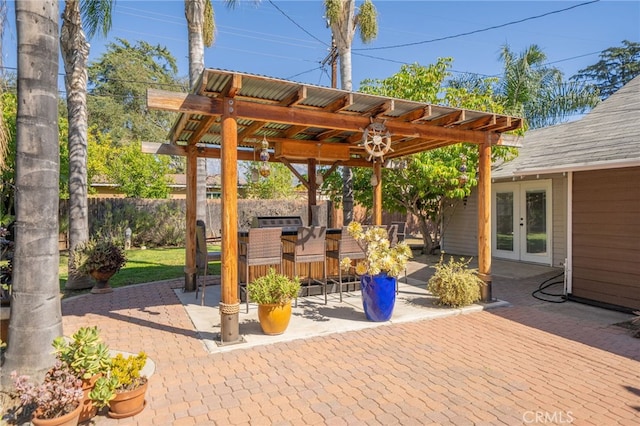 view of patio with french doors, outdoor dry bar, and fence