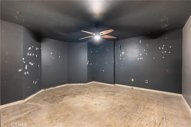 empty room with ceiling fan and baseboards