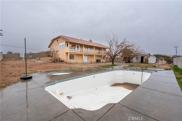 exterior space with a patio, an empty pool, a balcony, a jacuzzi, and fence