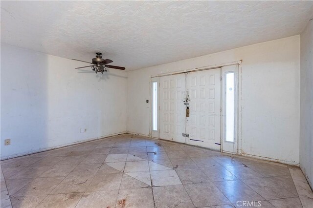 entryway featuring a ceiling fan and a textured ceiling