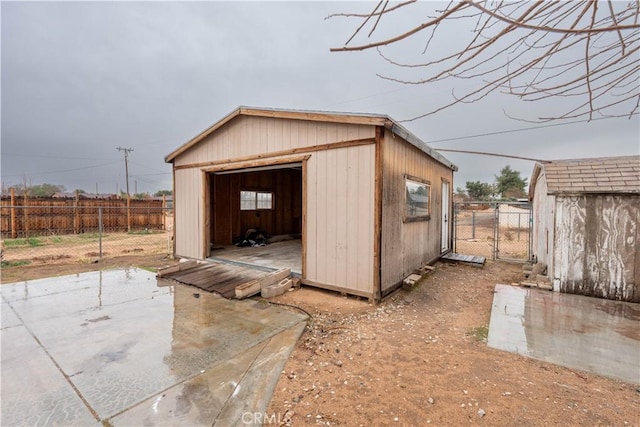 view of shed featuring a gate and fence