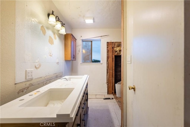 full bath with double vanity, a tub to relax in, and a sink