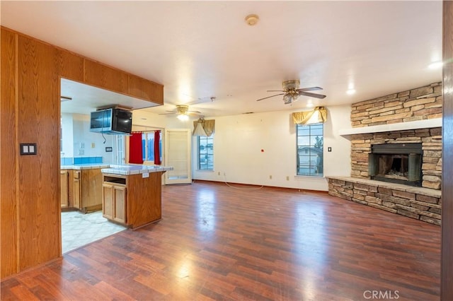 kitchen with open floor plan, brown cabinets, plenty of natural light, and wood finished floors