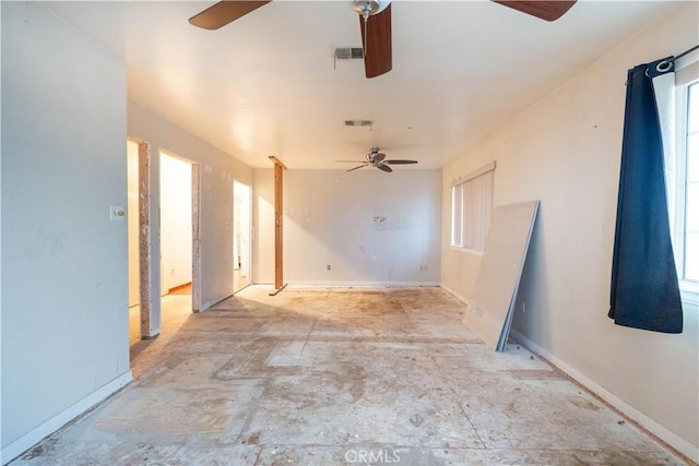 unfurnished room with ceiling fan, visible vents, and baseboards