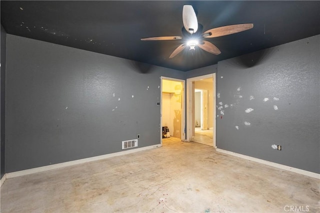 empty room with baseboards, visible vents, ceiling fan, and concrete flooring