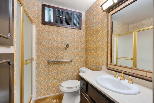 bathroom featuring a shower stall, vanity, and wallpapered walls