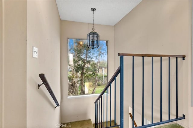 stairs with a notable chandelier