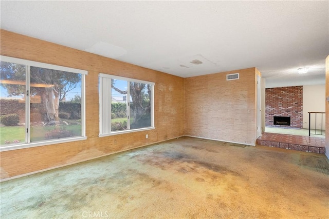 unfurnished living room with carpet, visible vents, and a fireplace