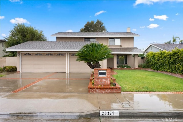 traditional-style home featuring an attached garage, concrete driveway, a shingled roof, and a front yard