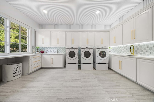 washroom with cabinet space, separate washer and dryer, a sink, and recessed lighting