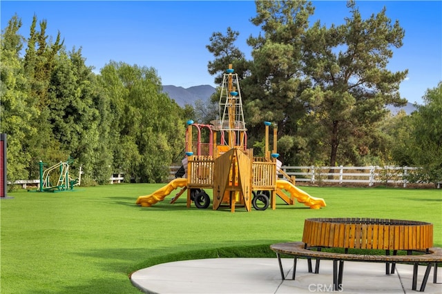 community playground with a lawn, fence, and a mountain view