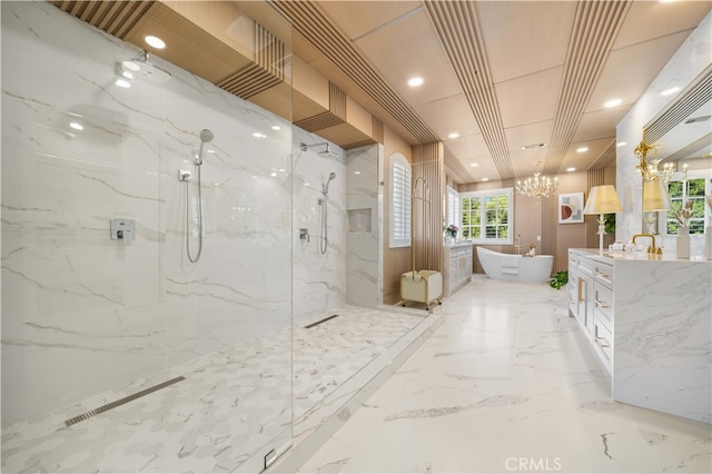 bathroom featuring a marble finish shower, a soaking tub, marble finish floor, vanity, and a notable chandelier