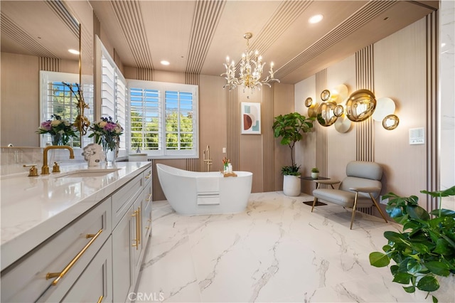 bathroom with a soaking tub, marble finish floor, vanity, a notable chandelier, and recessed lighting