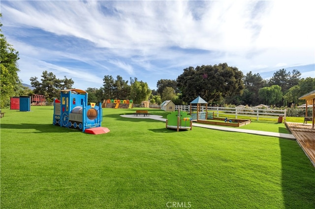 community jungle gym with a yard and fence