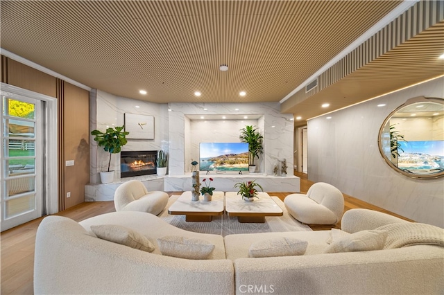 living area with visible vents, wood finished floors, a high end fireplace, and recessed lighting