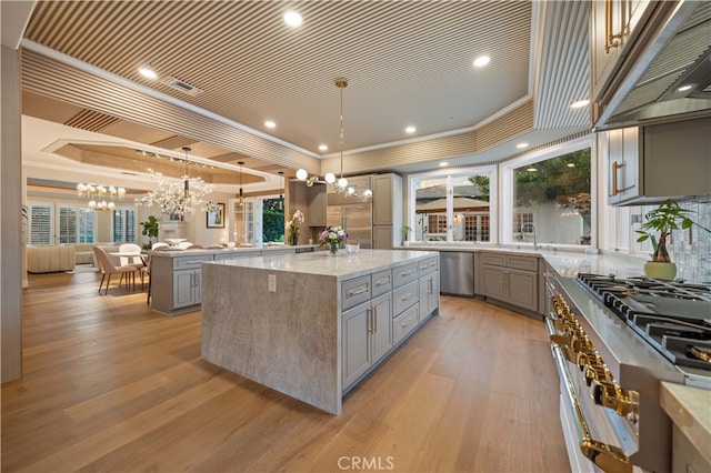 kitchen with appliances with stainless steel finishes, a raised ceiling, and gray cabinetry