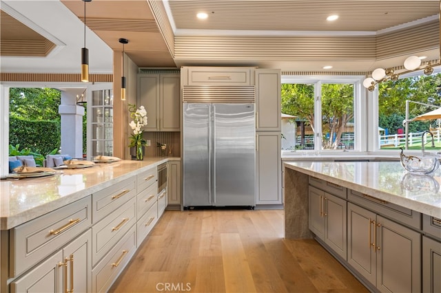 kitchen with light wood-style floors, gray cabinets, light stone counters, and stainless steel built in fridge