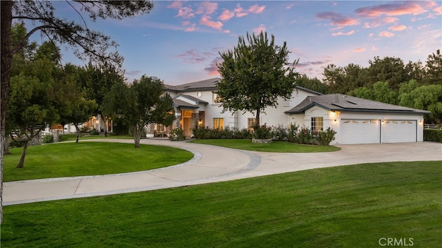 view of front facade featuring solar panels, curved driveway, a lawn, and stucco siding