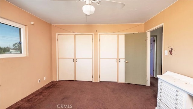 unfurnished bedroom with two closets and carpet flooring