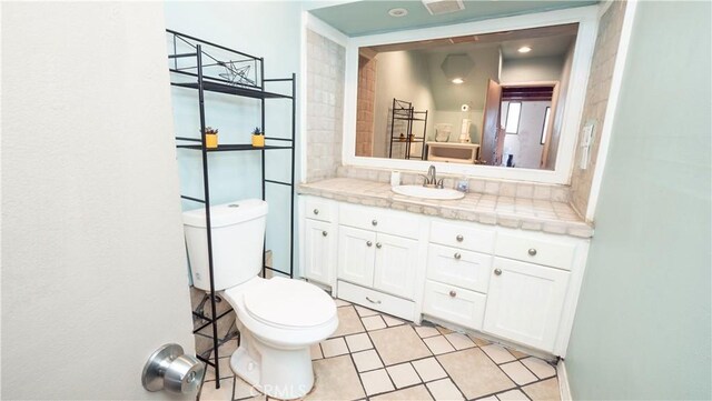 bathroom with toilet, tile patterned floors, and vanity