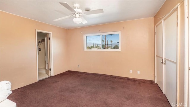 unfurnished bedroom with dark carpet and ceiling fan