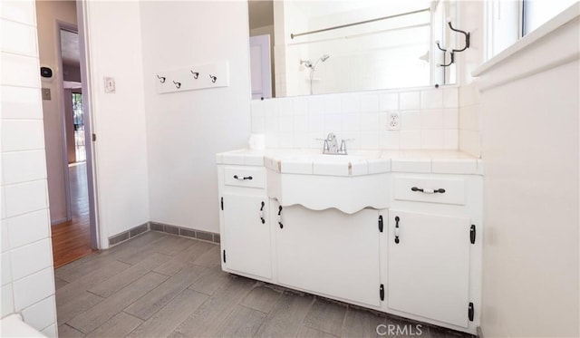 interior space featuring wood finished floors, plenty of natural light, backsplash, and vanity