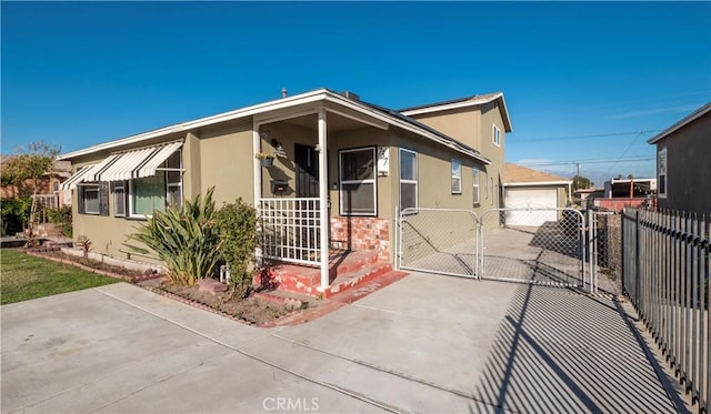 view of front of home with fence, a gate, and stucco siding