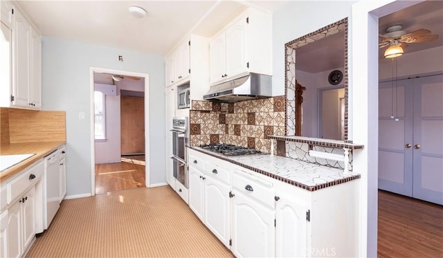 kitchen featuring ceiling fan, appliances with stainless steel finishes, under cabinet range hood, white cabinetry, and backsplash