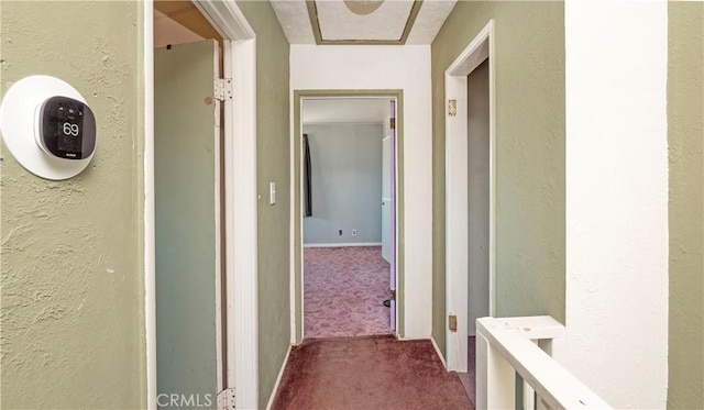 corridor featuring a textured wall and carpet