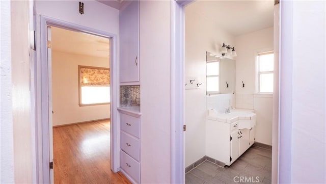 bathroom with tasteful backsplash, vanity, and wood finished floors