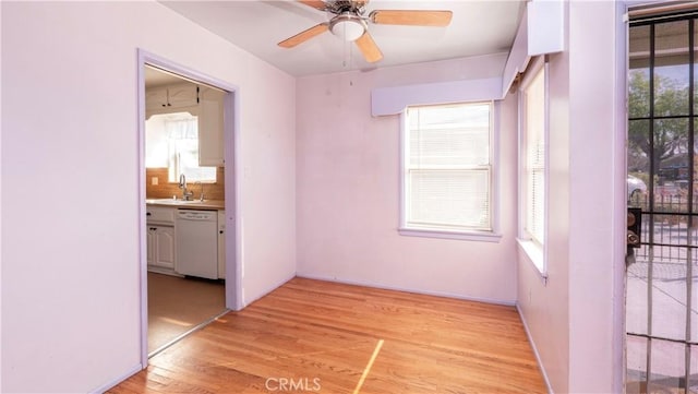 empty room featuring light wood-style floors, a sink, and ceiling fan