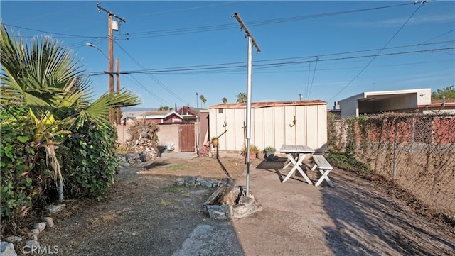 view of yard featuring an outbuilding, a storage unit, and a fenced backyard