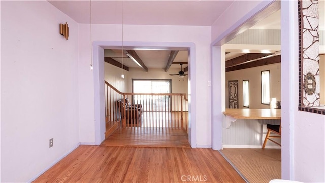 interior space featuring beamed ceiling, stairway, baseboards, and wood finished floors